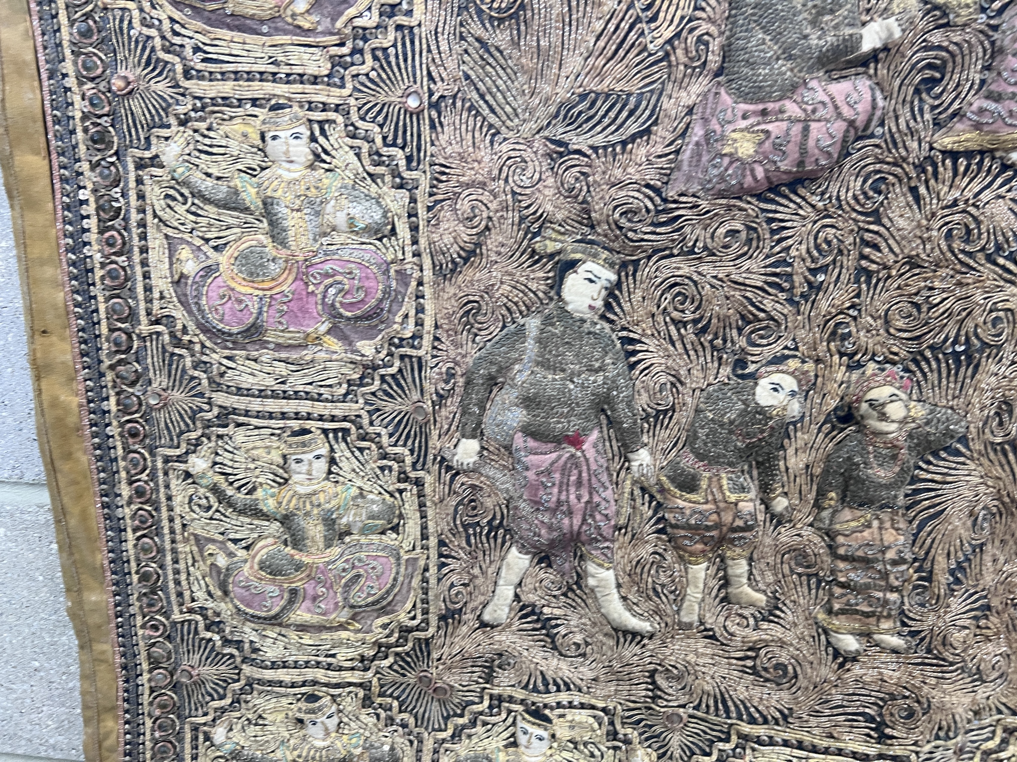 An Indian bullion work embroidered wall panel, depicting figures in a forest, width 124cm, height 90cm